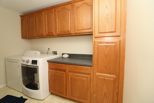 laundry room with washer and clothes dryer and cabinets