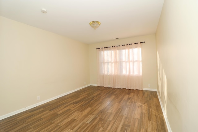 empty room with dark hardwood / wood-style flooring