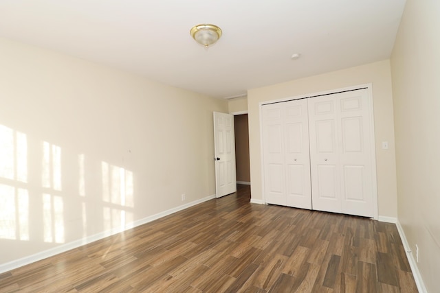 unfurnished bedroom featuring dark hardwood / wood-style flooring and a closet