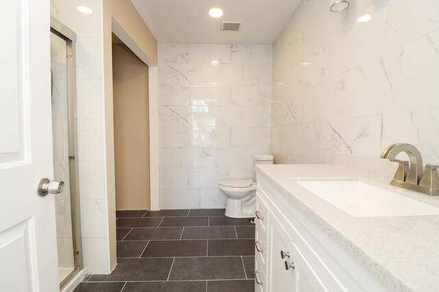 bathroom featuring vanity, tile patterned flooring, toilet, tile walls, and walk in shower