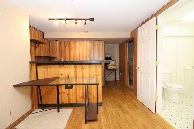 kitchen featuring kitchen peninsula, light wood-type flooring, rail lighting, and a breakfast bar area