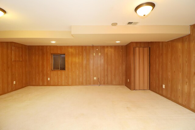 basement featuring wood walls and light carpet