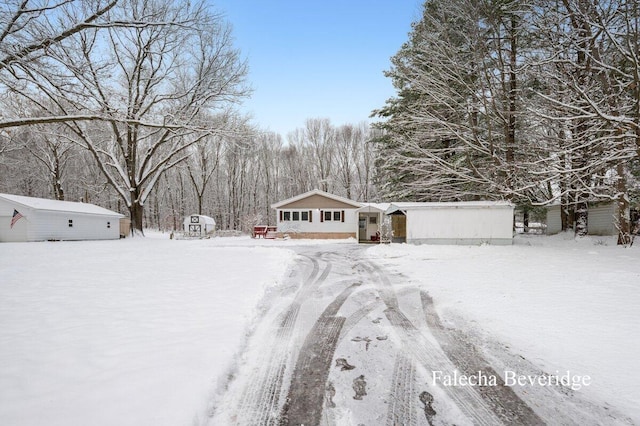 snowy yard featuring an outbuilding