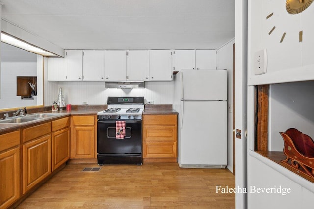 kitchen with black range with gas stovetop, sink, white refrigerator, light hardwood / wood-style flooring, and white cabinetry