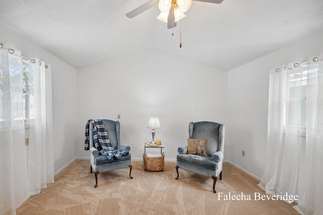 sitting room featuring ceiling fan, light colored carpet, and vaulted ceiling