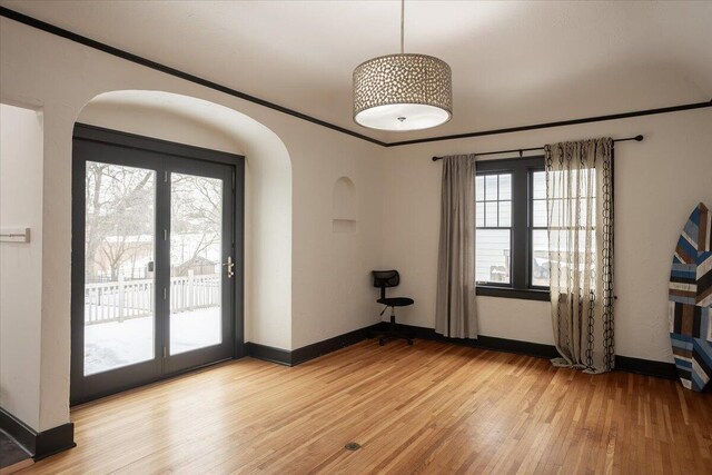 spare room with light wood-type flooring and crown molding