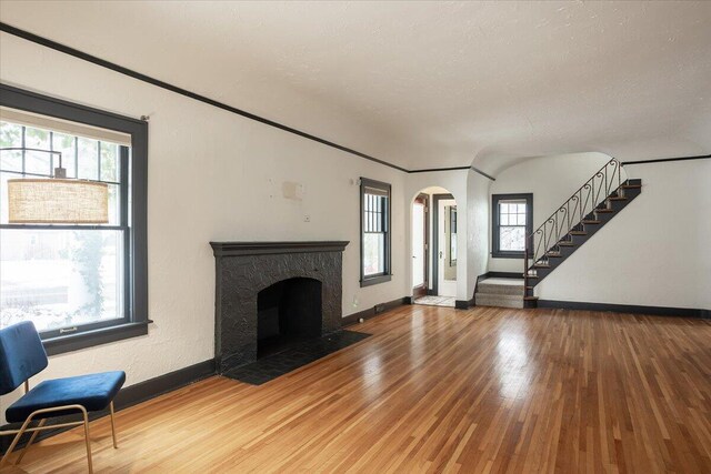 unfurnished living room featuring crown molding, hardwood / wood-style floors, and plenty of natural light