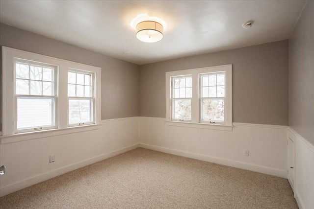 unfurnished room with carpet flooring and plenty of natural light