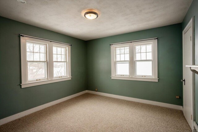 spare room with carpet flooring and a textured ceiling