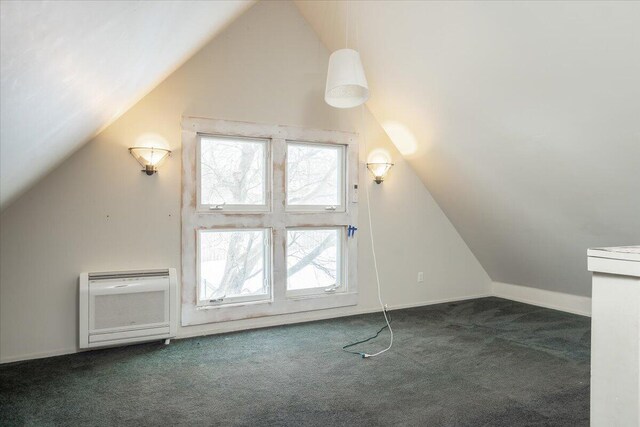 bonus room featuring dark carpet, lofted ceiling, and heating unit