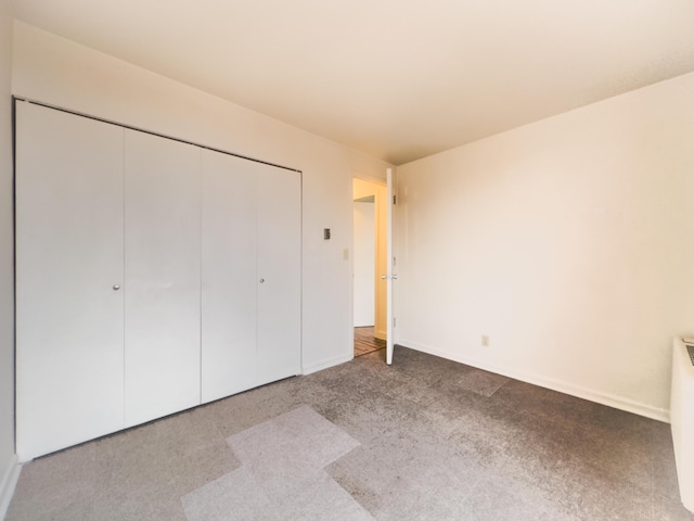 unfurnished bedroom with light carpet and a closet