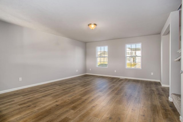 empty room with dark hardwood / wood-style flooring