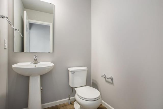 bathroom featuring hardwood / wood-style floors and toilet