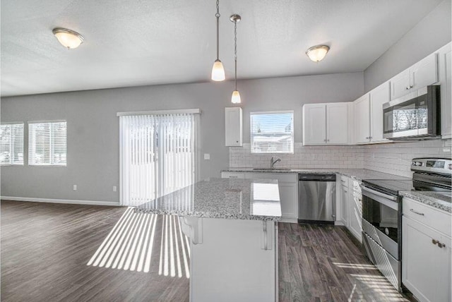 kitchen with white cabinets, stainless steel appliances, dark hardwood / wood-style floors, and hanging light fixtures