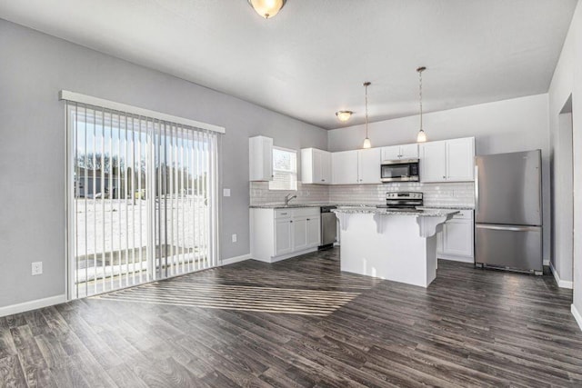 kitchen featuring white cabinetry, a center island, hanging light fixtures, dark wood-type flooring, and stainless steel appliances