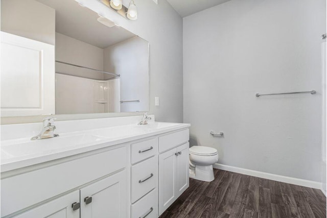 bathroom with hardwood / wood-style floors, vanity, and toilet