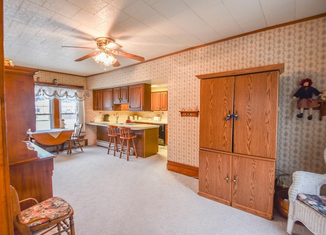 kitchen with a kitchen bar, light carpet, ceiling fan, and ornamental molding