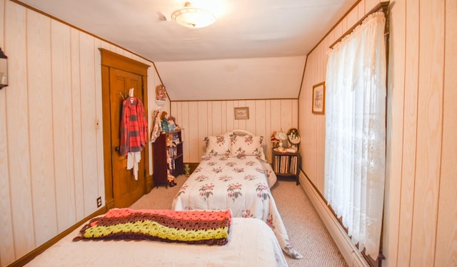 bedroom with carpet floors, vaulted ceiling, and wooden walls