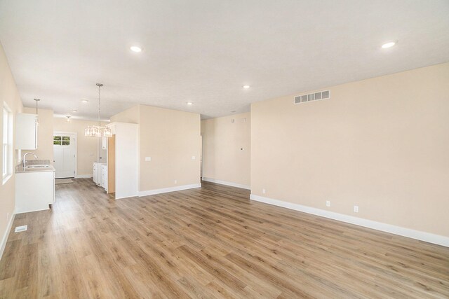 unfurnished room featuring sink and light hardwood / wood-style floors