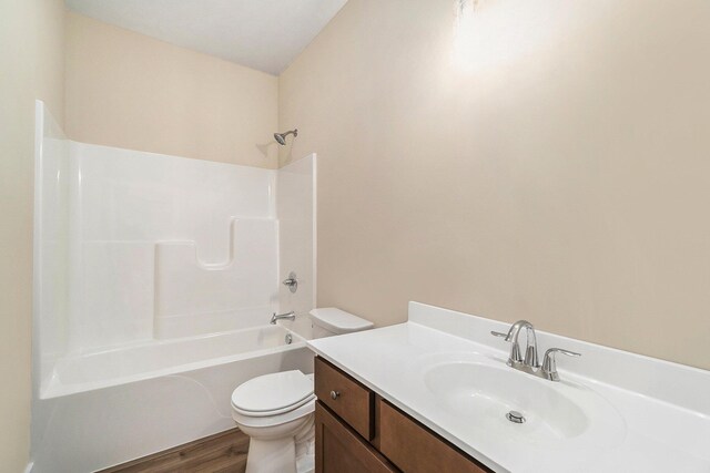 full bathroom with vanity, wood-type flooring, toilet, and washtub / shower combination