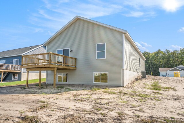 rear view of property featuring a wooden deck and central air condition unit