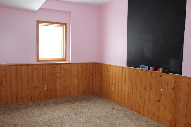 empty room with wood walls and carpet