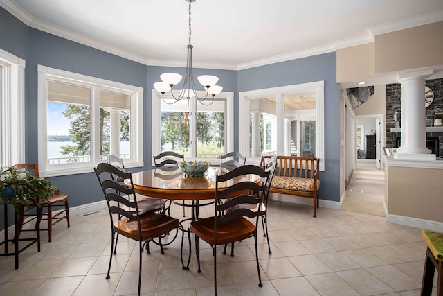 tiled dining room featuring crown molding, an inviting chandelier, and ornate columns