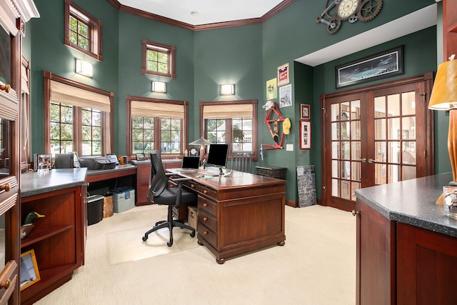 carpeted home office featuring crown molding, a towering ceiling, and french doors