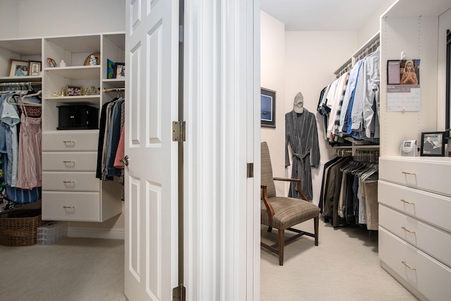 walk in closet featuring light carpet