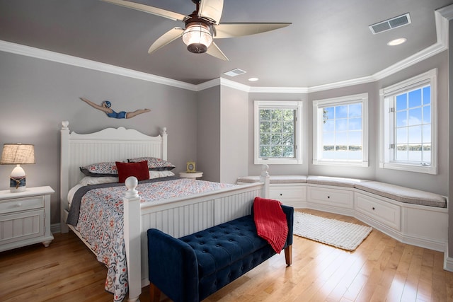 bedroom with crown molding, ceiling fan, multiple windows, and light hardwood / wood-style flooring