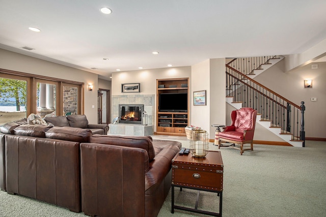 carpeted living room featuring a tiled fireplace