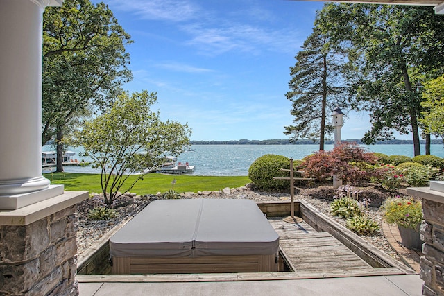 exterior space featuring a covered hot tub and a water view