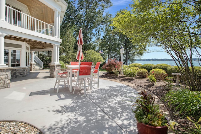 view of patio / terrace featuring a water view and a balcony