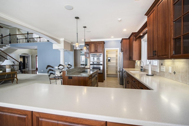 kitchen featuring decorative columns, sink, decorative backsplash, ornamental molding, and stainless steel appliances