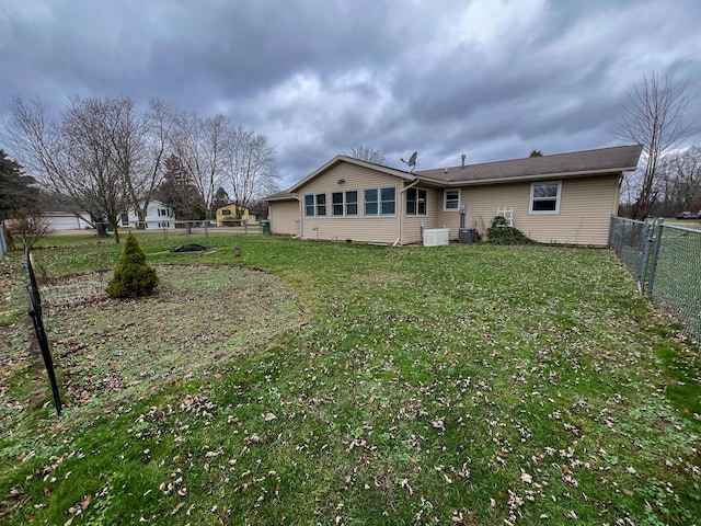 back of property featuring a yard and central AC