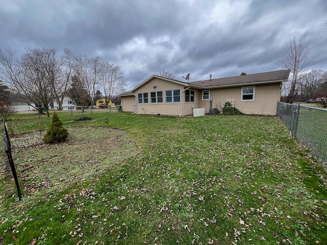 rear view of house featuring a yard and central AC unit