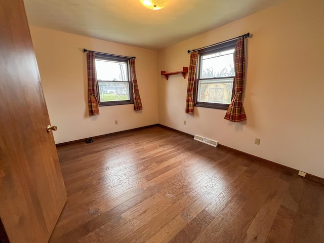 spare room featuring hardwood / wood-style floors and a healthy amount of sunlight