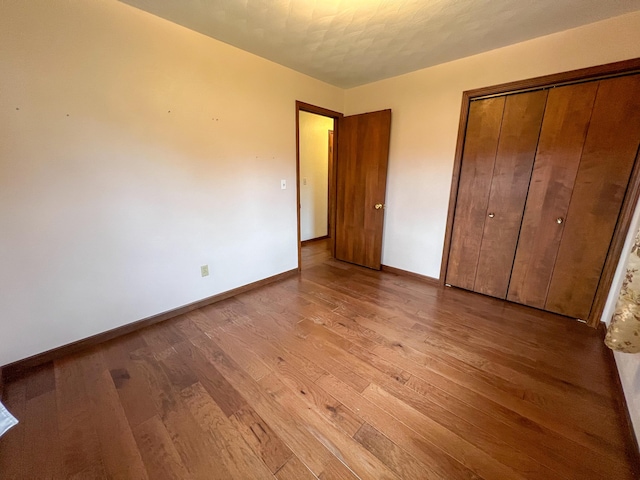 unfurnished bedroom with light wood-type flooring and a closet