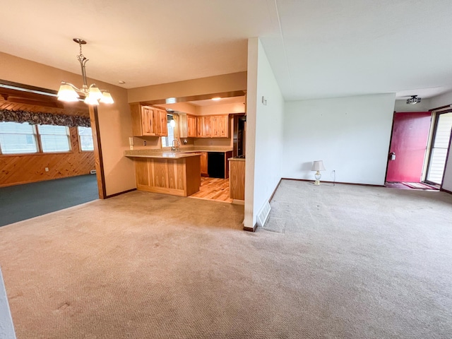 unfurnished living room featuring a notable chandelier, sink, and light carpet