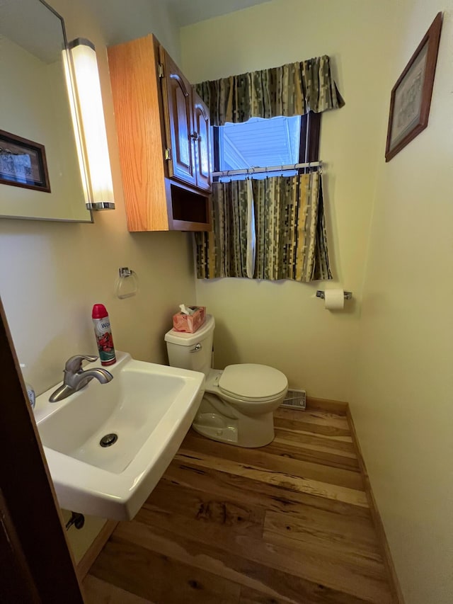 bathroom with hardwood / wood-style floors, toilet, and sink