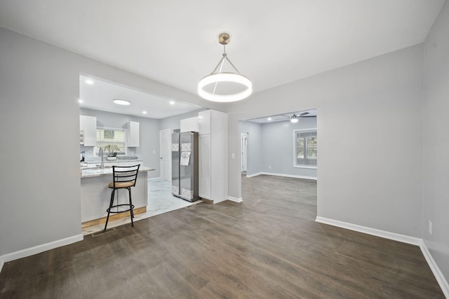 unfurnished dining area with dark hardwood / wood-style floors, ceiling fan, and sink