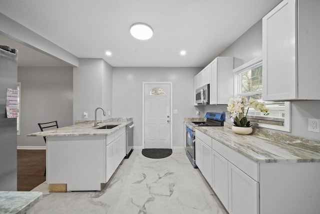 kitchen featuring white cabinets, sink, kitchen peninsula, and stainless steel appliances