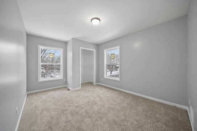 unfurnished bedroom with light carpet and a closet