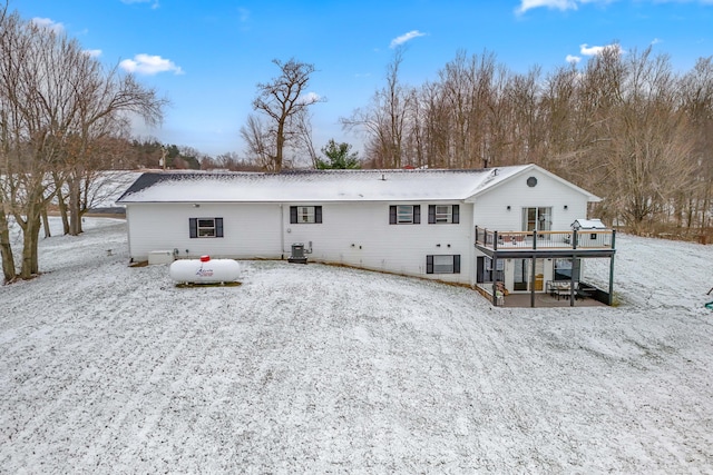 snow covered house with cooling unit and a deck