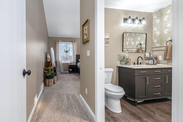 bathroom with vanity, toilet, and lofted ceiling