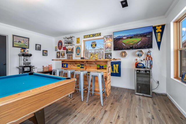 game room featuring wine cooler, crown molding, hardwood / wood-style floors, bar, and pool table