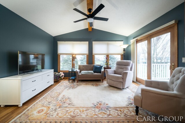 living room featuring ceiling fan, wood-type flooring, and vaulted ceiling