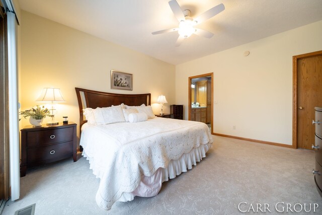 carpeted bedroom featuring ensuite bath and ceiling fan