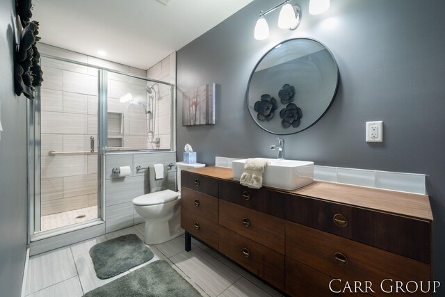 bathroom with vanity, toilet, and a shower with door