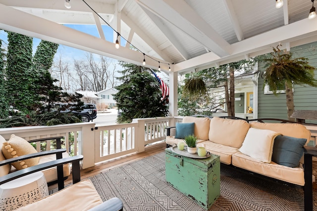 wooden terrace with an outdoor living space